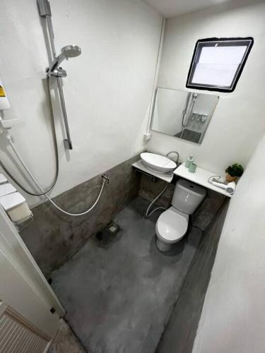 a bathroom with a shower and a toilet and a sink at Night Delight in Baan Tai