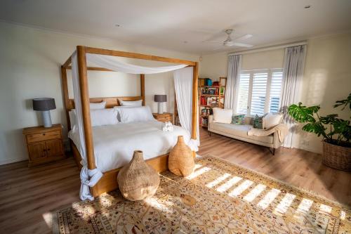 ein Schlafzimmer mit einem Himmelbett und ein Wohnzimmer in der Unterkunft Salt House in Kapstadt