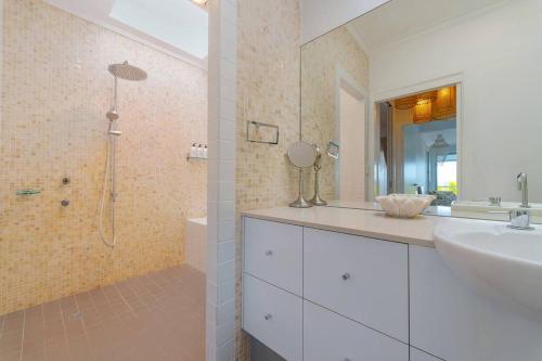 a white bathroom with a sink and a shower at Lee Lane Beach House - Lighthouse Rd Byron in Byron Bay