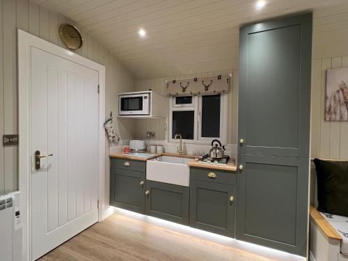 a kitchen with a sink and a microwave at Southfield Shepards Huts in Durham