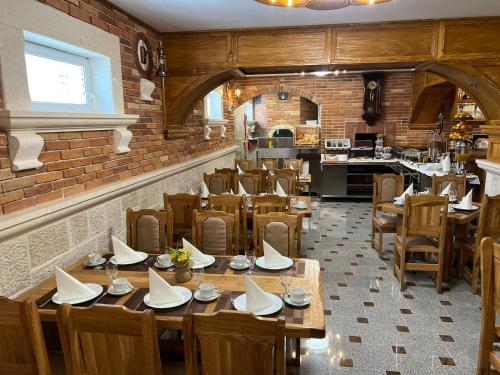 a restaurant with wooden tables and chairs and a brick wall at Pansion Dovodja in Vodice