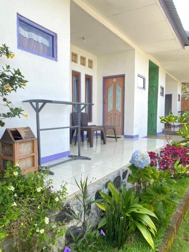 a front porch of a house with a wooden door at Mahoni Guest House in Kelimutu