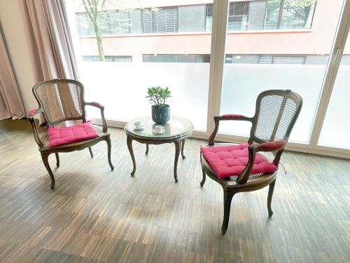 two chairs and a table in a room with a window at presence: grosszüges Loft_ bis 6 Pers_zentral in Luzern