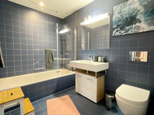 ein blau gefliestes Bad mit WC und Waschbecken in der Unterkunft presence: grosszüges Loft_ bis 6 Pers_zentral in Luzern