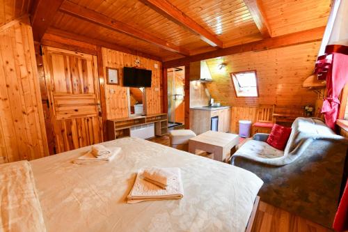 a wooden room with a table and a couch and a television at Guest House Martin in Korana