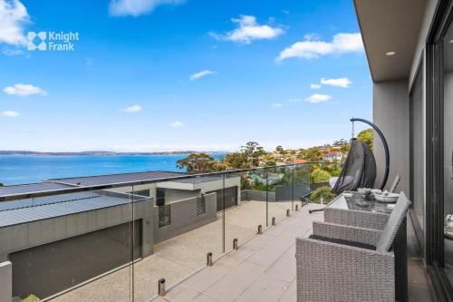an apartment balcony with a view of the water at Beachside Luxury Villa - Expansive Panoramic Vistas in Kingston Beach