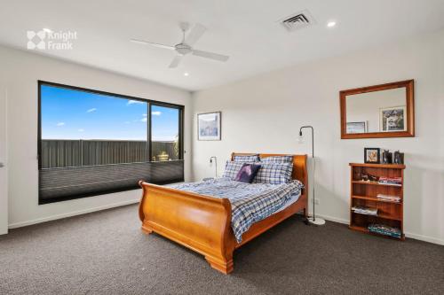 a bedroom with a bed and a large window at Beachside Luxury Villa - Expansive Panoramic Vistas in Kingston Beach