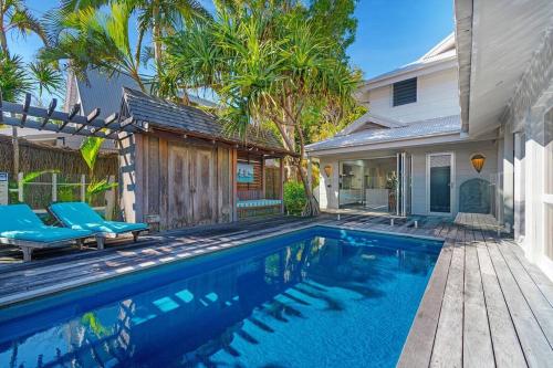 a swimming pool in front of a house at Fuller Holidays - Adrift - Tallows Beachfront Suffolk Park in Suffolk Park