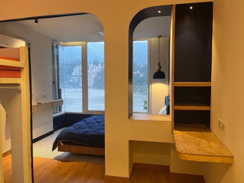um quarto com um espelho, uma cama e uma janela em Joey's By The Ganges em Rishikesh