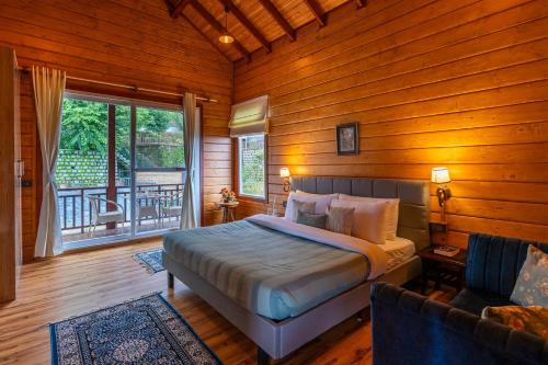 a bedroom with a bed and a window and a couch at StayVista at Villa Vivendi - 4 BR villa in Dharamshala in Dharamshala
