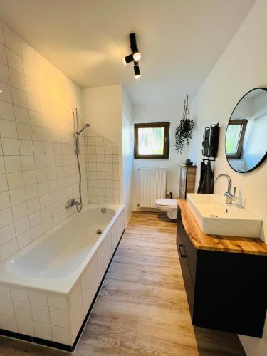 a bathroom with a large tub and two sinks at Landliebe in Schonungen