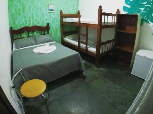 a bedroom with two bunk beds and a table at Pousada Relíquias do Mar in Arraial do Cabo