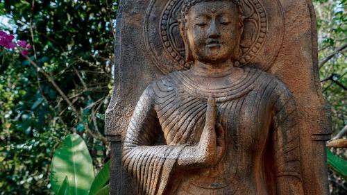 a statue of a woman holding a peace sign at petra bianca uluwatu in Uluwatu