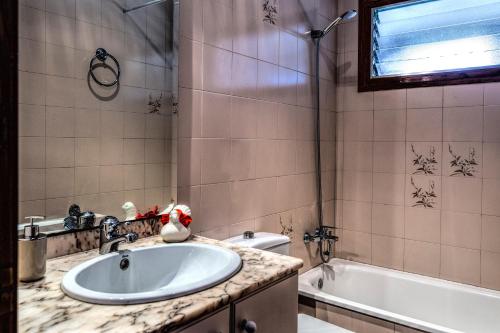 een badkamer met een wastafel en een bad bij Mas Espuña Turisme Entorn Rural in Sant Joan les Fonts