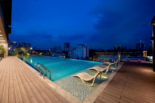 ein Schwimmbad auf dem Dach eines Gebäudes in der Nacht in der Unterkunft Societe Suite by Lyfehaus in Kuala Lumpur
