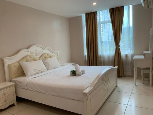 Simfoni Resort Langkawi في كواه: غرفة نوم مع سرير أبيض كبير مع نافذة