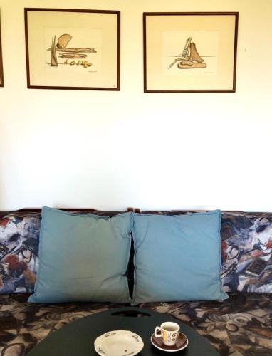 a couch with two blue pillows and a table at Elesta in Vourvourou