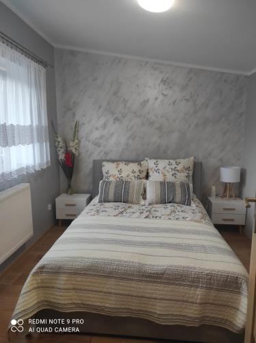a bedroom with a large bed with a concrete wall at Dawna Mleczarnia Apartament FAMILIJNY in Nowa Ruda
