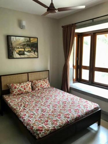 a bedroom with a bed with a flowered blanket and a window at Luxury Villa Large Private Pool in Raichak