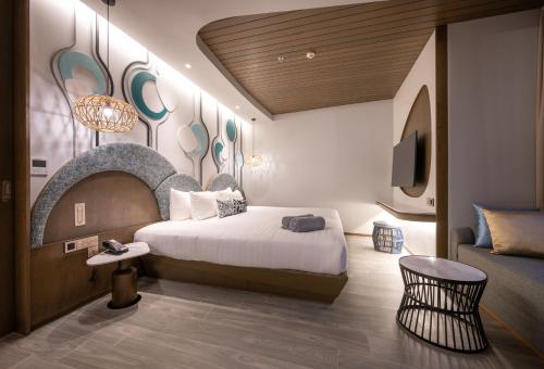 カタビーチにあるMetadee Concept Hotelのベッドとテレビ付きのホテルルーム