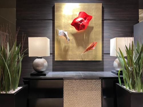 a painting of a red flower on a wall at KOKO HOTEL Premier Kanazawa Korinbo in Kanazawa