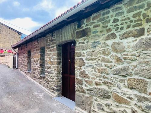 un edificio de ladrillo con una puerta de madera. en La So Casa -En el corazón de Asturias, en Armiello