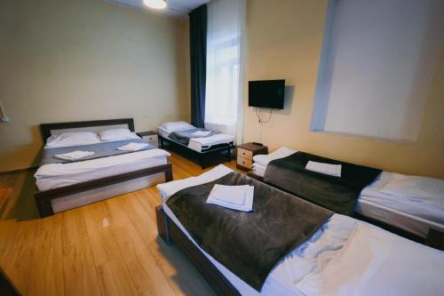 Cette chambre comprend 3 lits et une télévision à écran plat. dans l'établissement Villa Mestia Hotel, à Mestia