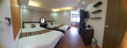 a hotel room with two beds and a mirror at Phuong Nam Hotel in Sa Pa