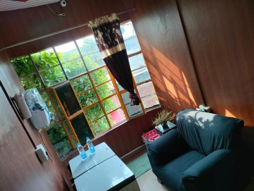 a living room with a couch and a table and a window at Kishan Home Stay in Mathura