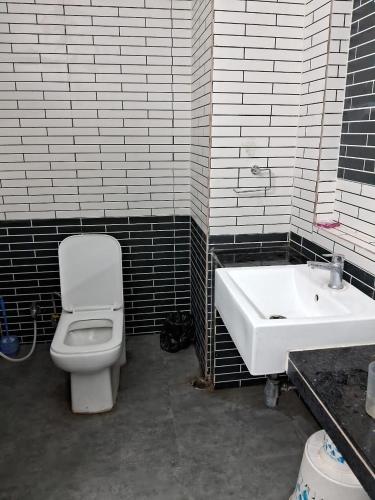 a bathroom with a white toilet and a sink at Luxury Villa Large Private Pool in Raichak