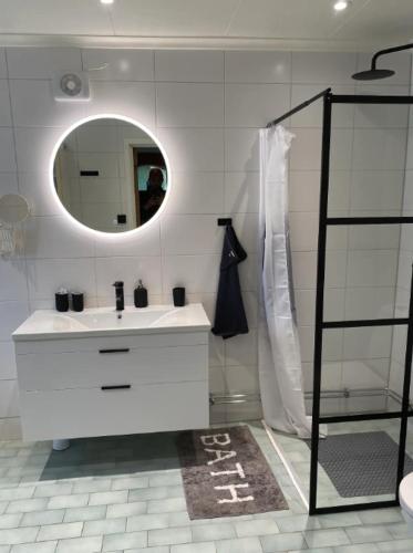 a white bathroom with a sink and a mirror at Hus nära Hallstaberget in Sollefteå
