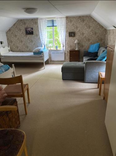 ein Wohnzimmer mit einem Sofa und einem Bett in der Unterkunft Hus nära Hallstaberget in Sollefteå