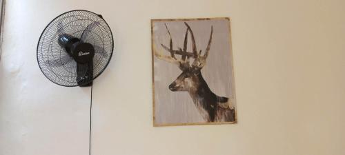 a fan and a picture of a deer on a wall at Dana Gardens Hotel in Dana