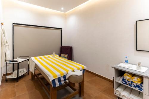 a room with a table with a yellow and white striped blanket at Vanaashrya Resort and Spa Sariska in Tehla