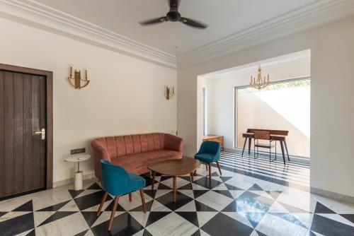 a living room with a couch and a table and chairs at Vanaashrya Resort and Spa Sariska in Tehla