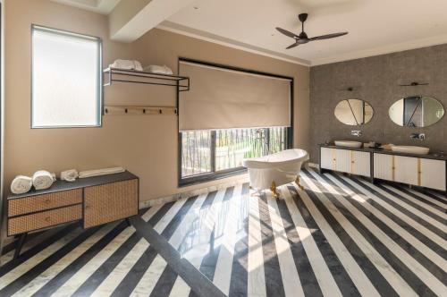 a bathroom with a tub and a sink at Vanaashrya Resort and Spa Sariska in Tehla