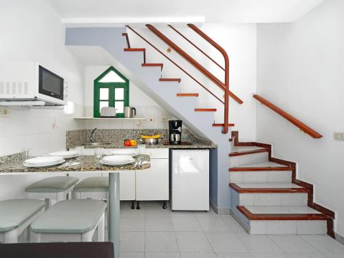 a kitchen with a staircase and a counter with stools at Bungalows Vistaflor in Maspalomas