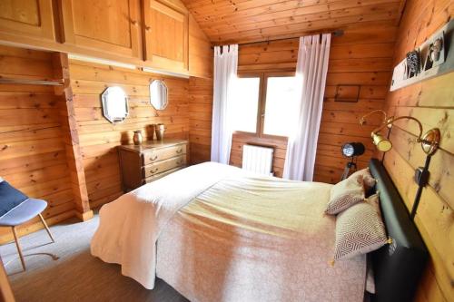 a bedroom with a bed in a wooden cabin at Chalet cosy, cadre apaisant in Saint-Léonard
