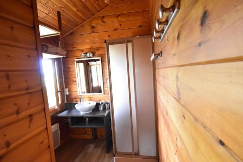 a bathroom with a sink in a wooden cabin at Chalet cosy, cadre apaisant in Saint-Léonard