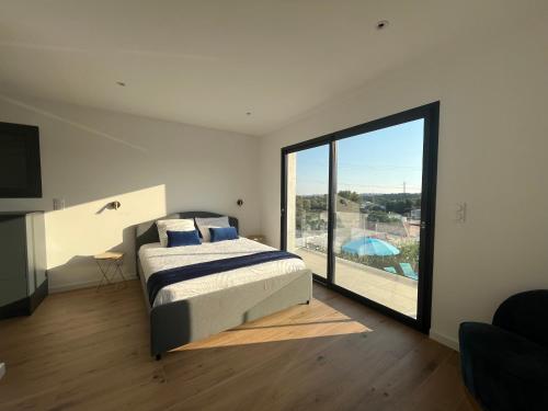 a bedroom with a bed and a large window at Villa sun dream in Septèmes-les-Vallons