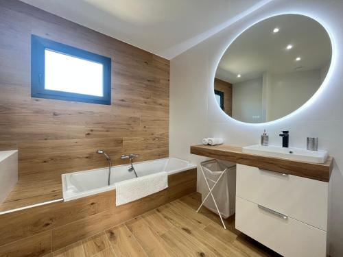 a bathroom with a tub and a sink and a mirror at Villa sun dream in Septèmes-les-Vallons