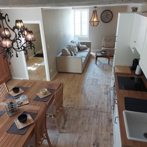 a kitchen and living room with a table and a couch at LES TROIS L in Gindou