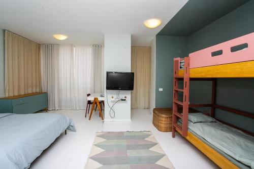 1 dormitorio con litera y TV de pantalla plana en Huge Ultra Luxury TLV Apartment, en Tel Aviv