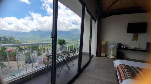 a bedroom with a balcony with a view of the mountains at Phuong Nam Hotel in Sa Pa