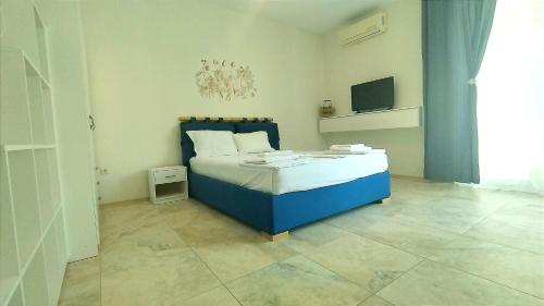 1 dormitorio con 1 cama azul y TV en Liberty Residence, en Primorsko