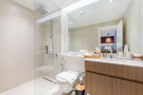 Un baño con ducha, inodoro y lavabo. en Manzil - 1BR Home in Port de la Mer w Lake Access, en Dubái