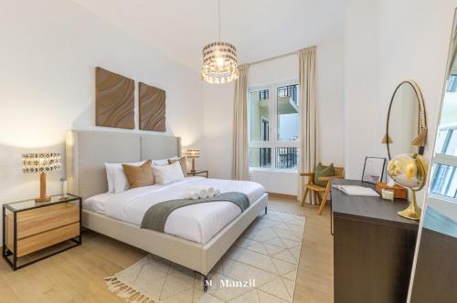 1 dormitorio con 1 cama, vestidor y escritorio en Manzil - 1BR Home in Port de la Mer w Lake Access, en Dubái