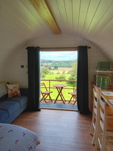 a room with a view of a table and a balcony at Coombs glamping pods in Danby