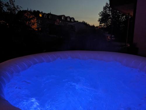 a large pool of blue water at night at FeWo Goldstück mit privatem SPA und Whirlpool in Grafenau