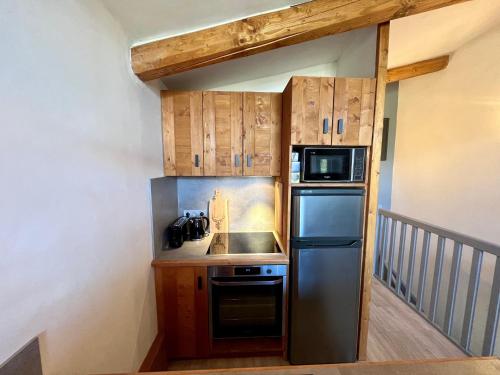 een kleine keuken met een koelkast en een magnetron bij Résidence Grand Bois A1124 Clés Blanches in La Tania